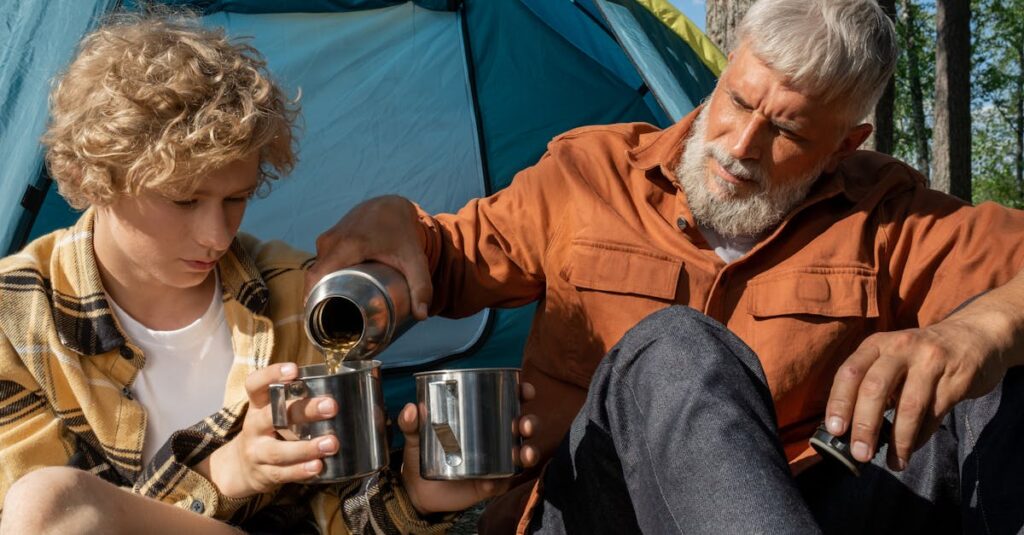 キャンプ場で温かいスープを囲んで笑顔の家族。テーブルにはポトフや豆乳スープが並び、ほっこりとした雰囲気が漂う。