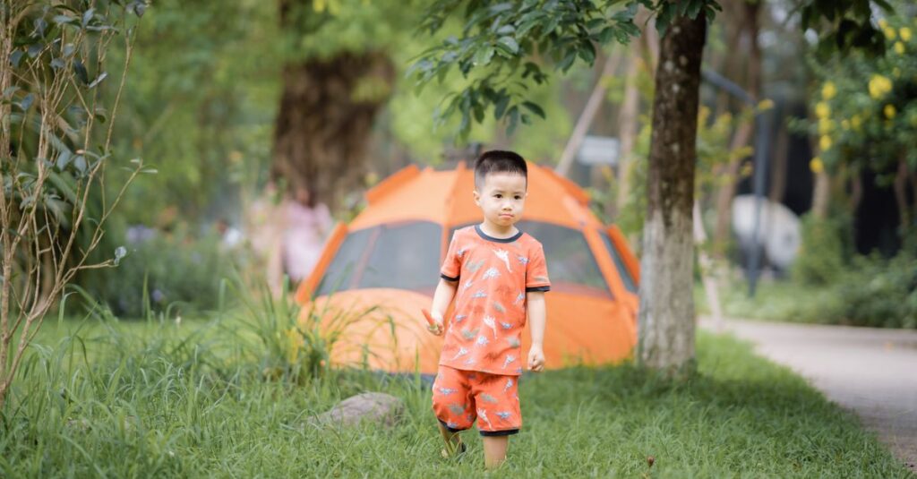 キャンプ場で葉っぱを集めたり虫を探したりして遊ぶ幼児の様子