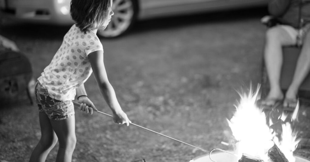 キャンプ場で葉っぱを集めたり虫を探したりして遊ぶ幼児の様子