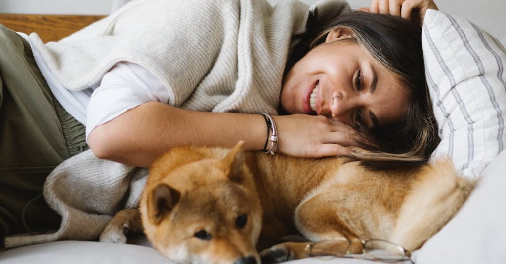 焚き火のそばでリラックスする犬と飼い主の夜のキャンプシーン