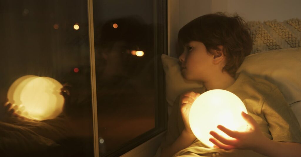 夜のキャンプ場で懐中電灯やランタンを使って遊ぶ子供たちの冒険風景