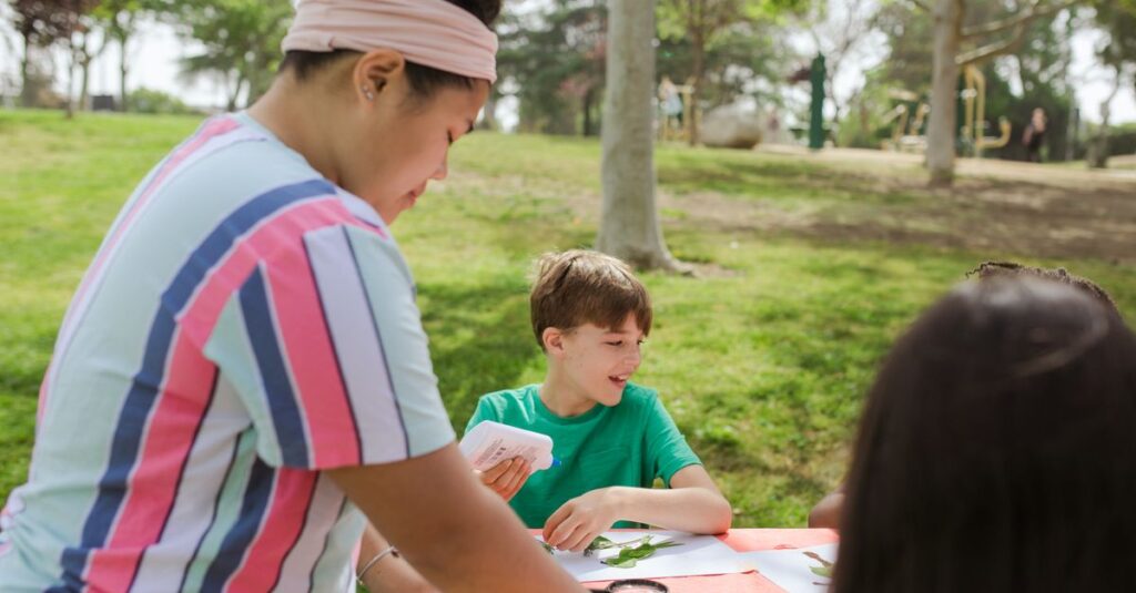 木の枝や葉っぱを使ってクラフト作りに夢中になる子供たちの様子