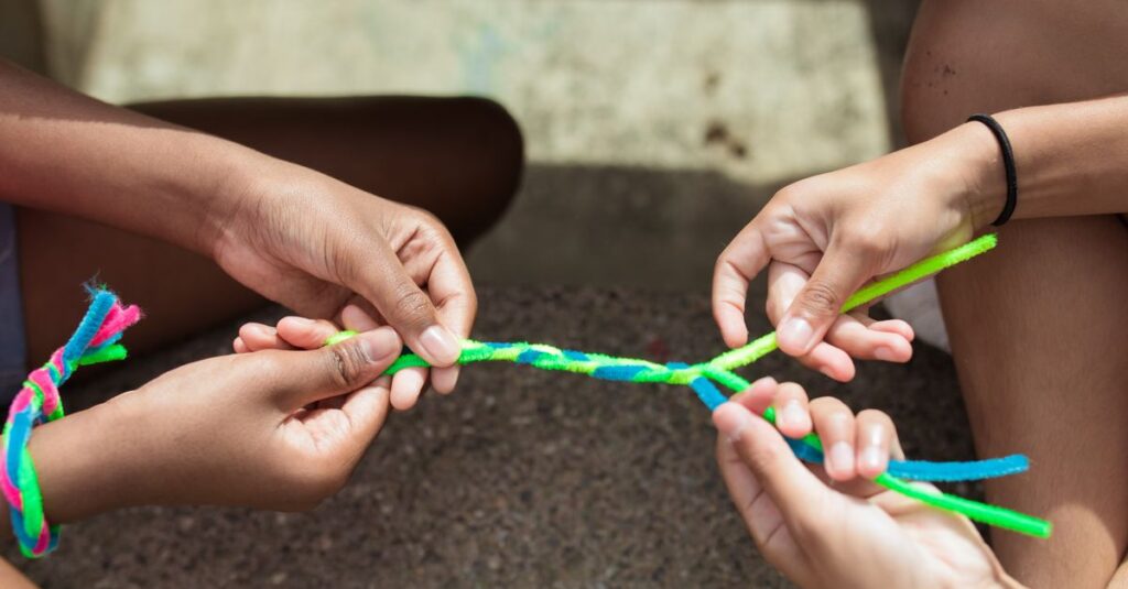 木の枝や葉っぱを使ってクラフト作りに夢中になる子供たちの様子