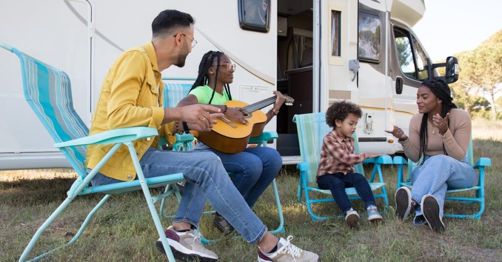 キャンプ場で家族が昼食を囲んで笑顔で過ごす風景。テーブルに並ぶ彩り豊かな料理と子どもたちの楽しそうな表情が印象的。