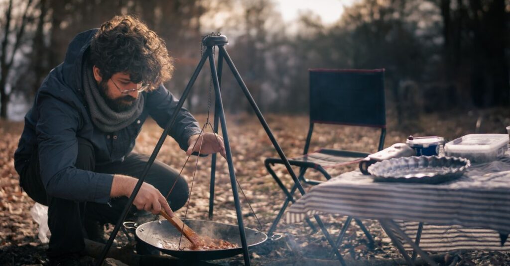 秋の食材を使ったキャンプ飯を焚き火で調理する様子を写した写真