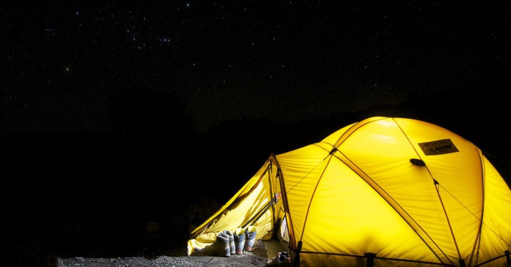星空の下で焚き火を囲みながら過ごす秋キャンプの幻想的な様子を写した写真